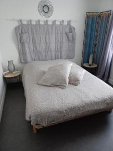 a bedroom with a bed with two pillows on it at Chez Anita in Plérin