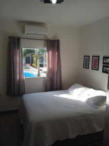 a bedroom with a bed and a window at Casa Bela no Rita Vieira in Campo Grande