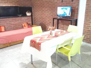 Monoambiente las lilas في بويرتو مادرين: غرفة طعام مع طاولة بيضاء وكراسي صفراء