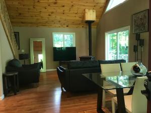 a living room with a couch and a table at Hidden Lakefront Retreat in Sherburne