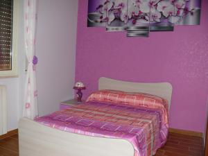 1 dormitorio con 1 cama con pared morada en B&B Max en Messina