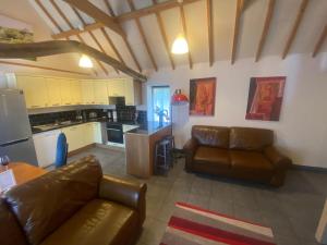 sala de estar con 2 sofás de cuero y cocina en Seafret Barn 4 plus 2, en Roughton
