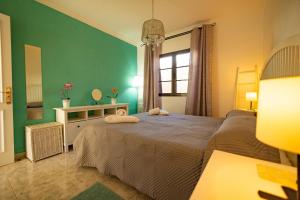 een slaapkamer met een groot bed en een groene muur bij Casa Lulu in Agaete