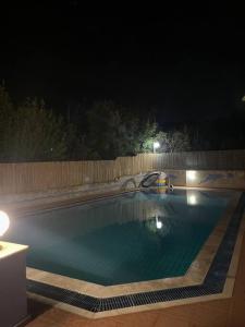 - une piscine dans un jardin la nuit dans l'établissement 4 Beds Flat with Shared Pool, à Stalida
