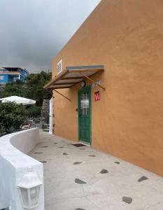 una puerta verde al lado de un edificio en Vivienda Vacacional El Pajar, en Breña Alta
