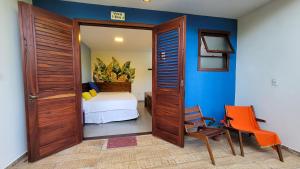 a room with a door and a chair and a bed at Pousada Casa Viva a Vida in Lençóis