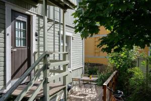 a porch with a table and a door on a house at Lovely SELF-SERVICE studio in wooden house, private bath&parking in Turku