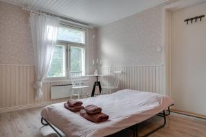 een slaapkamer met een bed met handdoeken erop bij Cosy home & terrace in a 1910-wooden house in Turku
