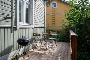 a patio with a table and chairs and a grill at Lovely SELF-SERVICE studio in wooden house, private bath&parking in Turku