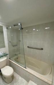 y baño con ducha, aseo y bañera. en apartamento poblado, en Medellín