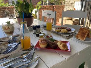 a table topped with plates of food and orange juice at 57 On Wellington Accommodation in Colchester