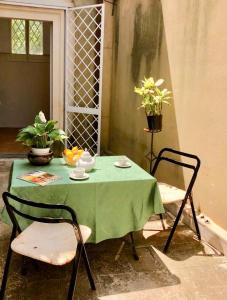レッチェにあるPalazzo Apostolico Orsiniのテーブル(緑のテーブルクロスと椅子2脚付)