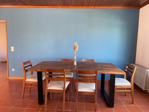 une table à manger avec des chaises et un mur bleu dans l'établissement Sunny Villa Minutes from the Beach, à Lourinhã