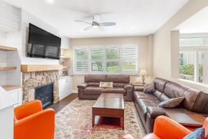a living room with a leather couch and a fireplace at Wintergreen 119 in Blue Mountains