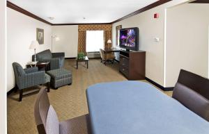 a hotel room with a living area with a tv and chairs at Hampton Inn Asheboro in Asheboro