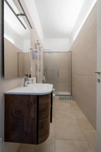 La salle de bains est pourvue d'un lavabo et d'une douche. dans l'établissement Riva Vieste Suites, à Vieste