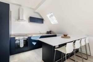 una cocina con armarios azules y encimeras blancas en 2 bed Seaside Apartment with Parking, en Southbourne