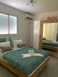 a bedroom with a bed with a heart towel on it at Charmante maison avec jacuzzi in Le Gosier