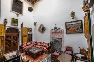 sala de estar con sofá y mesa en Riad Fes Allouch, en Fez