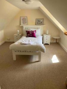 a bedroom with a white bed with purple pillows at 47 High Street in Alness