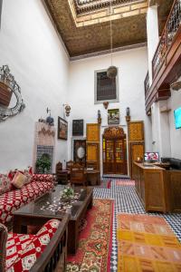 sala de estar con sofá y mesa en Riad Fes Allouch, en Fez