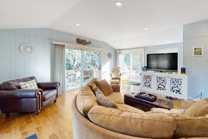 a living room with a large couch and a television at Cape Escape in West Yarmouth