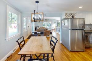a kitchen with a wooden table and a refrigerator at Cape Escape in West Yarmouth