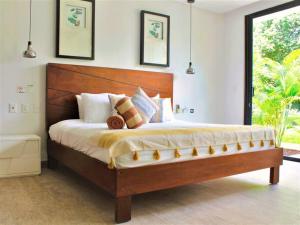 a bedroom with a large bed with a wooden headboard at Casita Oleaje Luxury Cultural Sanctuary Spa in Tulum +29 photos