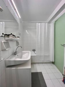 a white bathroom with a sink and a shower at Red Apartment wt Indoor Parking near Marousi Hospitals, by PromosHomes in Athens