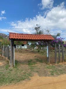 een houten paviljoen met een rood dak op een veld bij Casa Linha Férrea in Diamantina