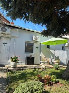 a house with a green umbrella in the yard at Sobe Šponga 4, in Kikinda