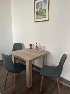 a wooden table with two chairs and a picture on the wall at Sobe Šponga 4, in Kikinda