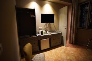 a hotel room with a dresser with a television on it at Bari Antica Boutique B&B in Bari