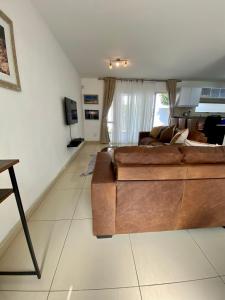 una sala de estar con un gran sofá marrón. en Catalea's Cousy home en Windhoek