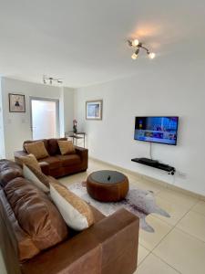 sala de estar con sofá y TV en Catalea's Cousy home en Windhoek
