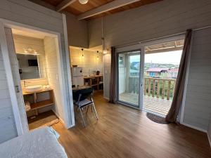 a room with a balcony with a bed and a desk at Amphibias in Punta Del Diablo