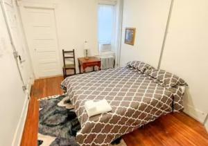 ein Schlafzimmer mit einem Bett mit einer braunen Decke in der Unterkunft Legacy - Spring Garden University City in Philadelphia