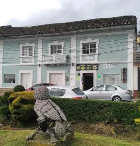 una estatua de un pájaro parado frente a una casa en El Andarin Home Stay en El Ángel