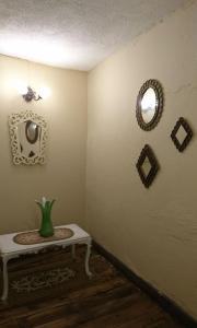 Habitación con mesa y espejo en la pared. en El Andarin Home Stay en El Ángel