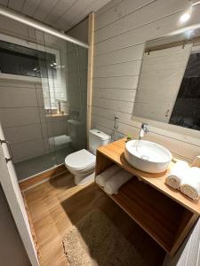 a bathroom with a sink and a toilet and a mirror at Amphibias in Punta Del Diablo