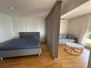 ein Schlafzimmer mit einem Bett, einem Sofa und einem Tisch in der Unterkunft Vila Ester - apartman Lovrana in Lovran