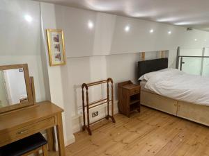 een slaapkamer met een bed, een dressoir en een spiegel bij City Centre 3 bedrooms apartment with parking in Nottingham