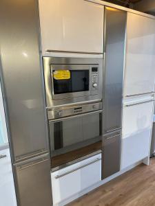 a kitchen with a stainless steel refrigerator and a microwave at City Centre 3 bedrooms apartment with parking in Nottingham