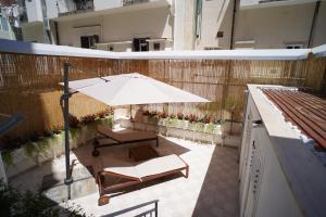 un patio con sombrilla, silla y mesa en Bari Antica Boutique B&B en Bari