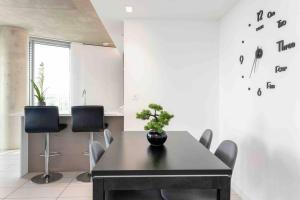 a dining room with a black table and chairs at Luxury Apt 3min walk to London Excel,City Hall, O2 in London