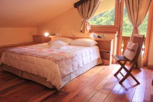 a bedroom with a bed and a desk and a chair at Shatush Hotel in Courmayeur