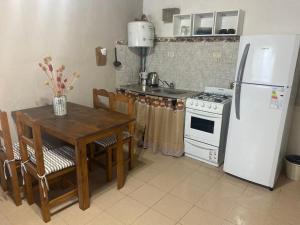 cocina con mesa y nevera blanca en Nuestro Lugar en Balneario Mar Azul