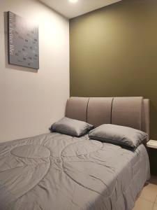 a bed in a room with two pillows on it at 7&9 Manhattan Condominium Ipoh in Ipoh