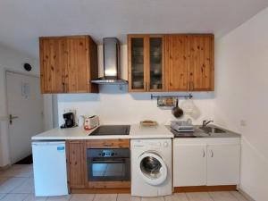 a kitchen with a sink and a washing machine at Studio 2* pour 2 avec balcon, WiFi, animaux admis - FR-1-512-118 in Brides-les-Bains