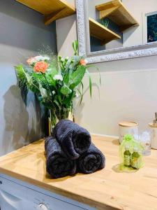 a towel laying on a counter with a vase of flowers at T2 Cosy climatisé 5 min aéroport in Blagnac